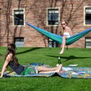 Students lounging on a hammock campus in the summertime